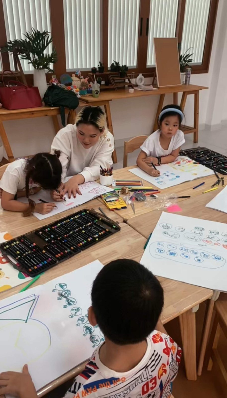 Children drawing around a table in an Arcko class