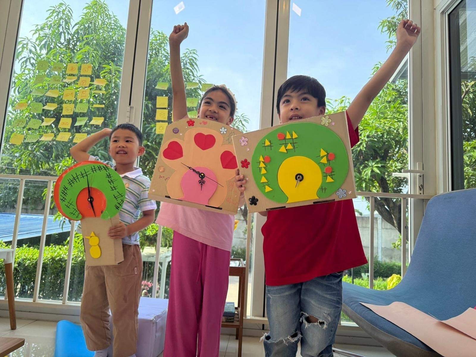 Three Arcko students presenting their colourful artwork